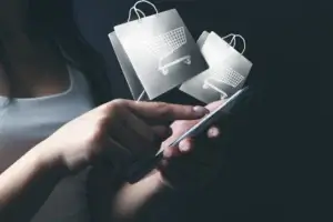 Nákup v e-shopu na mobilním telefonu s ikonami nákupních tašek