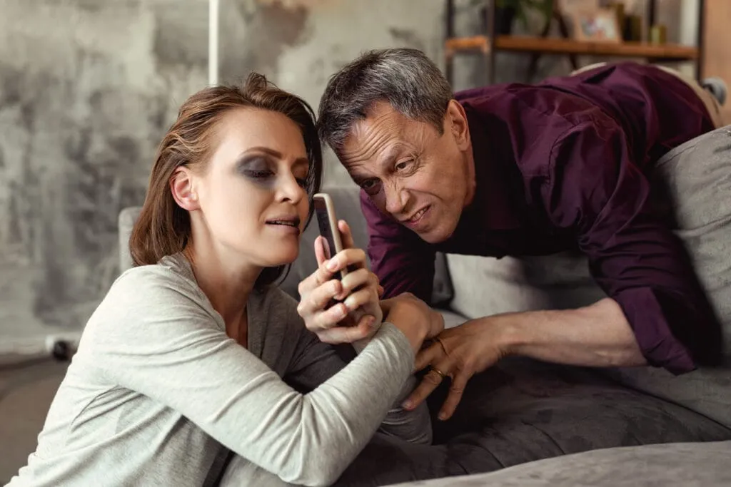 Dva lidé se smějí u obrazovky telefonu